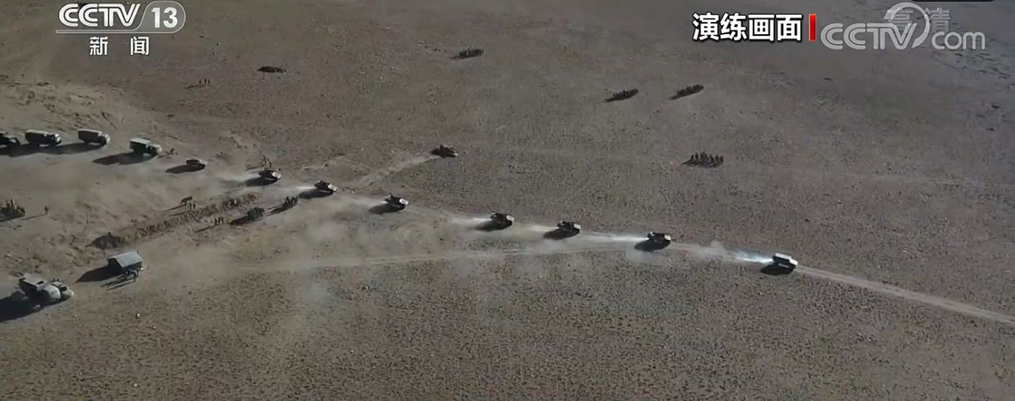 在7月14日的新闻报道中，参加前线“战备拉练”的解放军车队在高原地带保持机动，其观察视角展示了跟随部队的无人机群。（中国中央电视台截图）