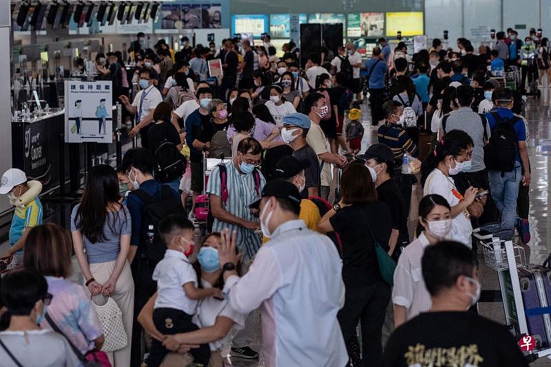 香港国际机场办理登机手续柜台前，昨天排满了准备离港飞往英国的香港人，与亲友道别的声音此起彼落。（法新社）