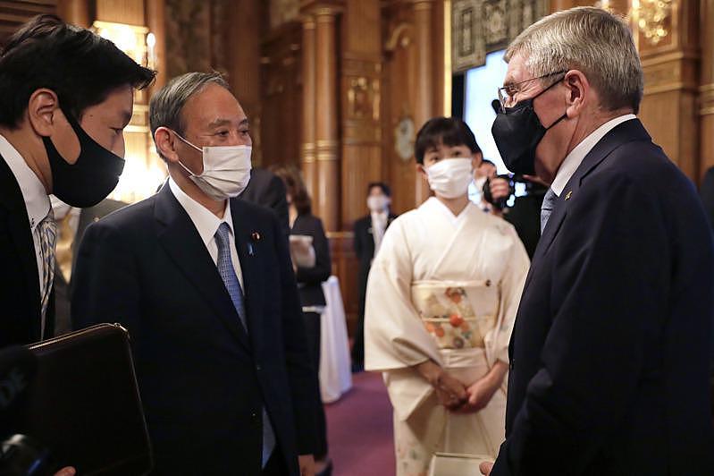 日本首相菅义伟(左)18日在东京的赤坂迎宾馆，欢迎国际奥委会主席巴赫(右)等官员...