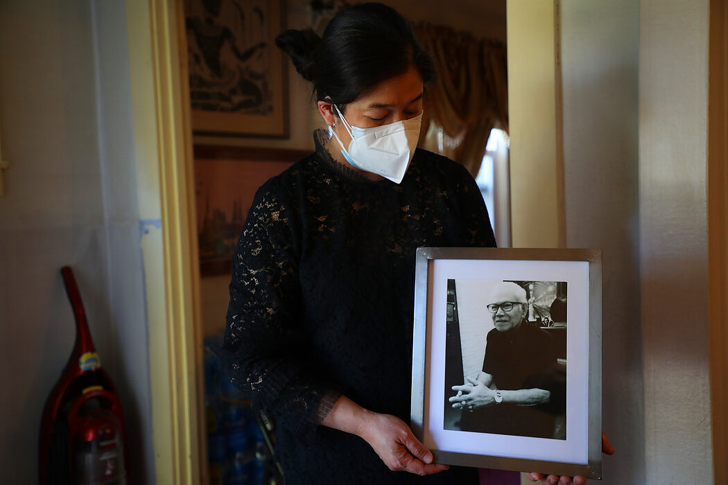 蒙塔努斯·拉塔纳帕克迪抱着父亲维查·拉塔纳帕克迪的照片，她的父亲被人推倒在地，受伤去世。