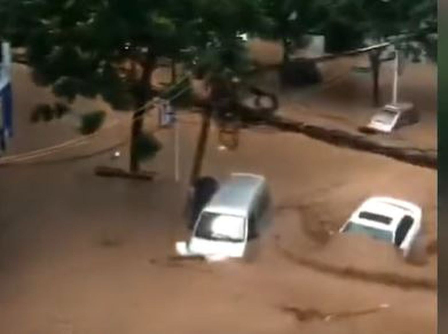 根据网友提供的视频可以看到，寄料镇内街道已被洪水淹没，河水湍急。停放在街道上的多辆汽车随着洪水被冲走，转瞬间，一辆小轿车就被冲入河中，淹没在河水里消失不见。（视频截图）
