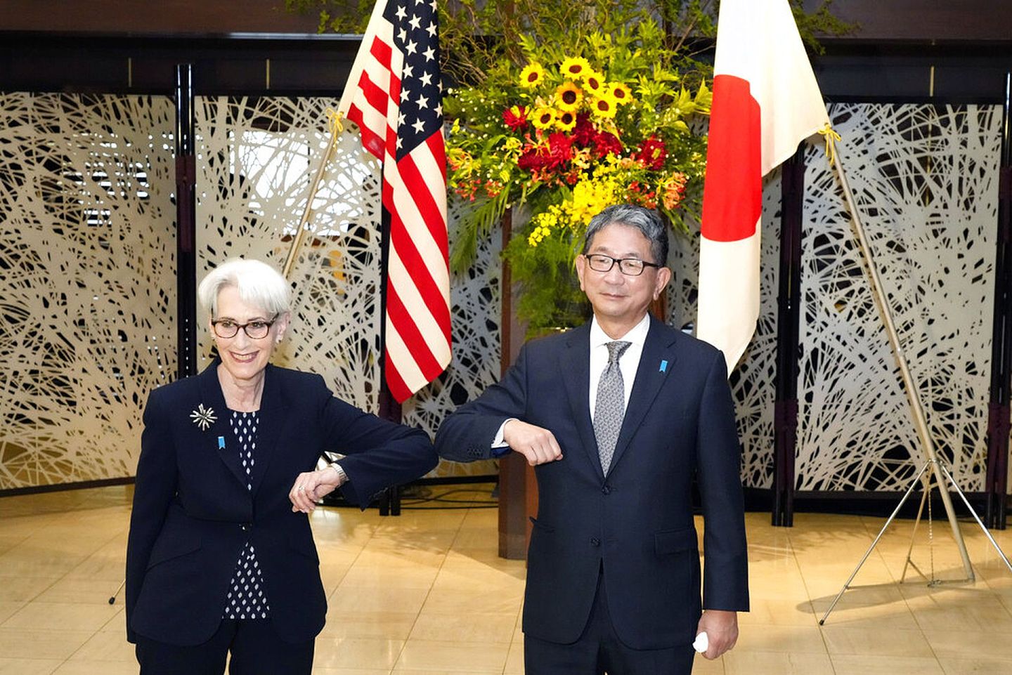 2021年7月20日，美国副国务卿谢尔曼（左）与日本外务省副大臣森健良（右）在东京举行会谈前撞肘致意。（AP）