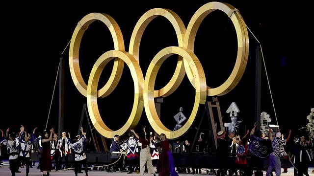 Performers dance in front of a giant golden Olympic Rings during the Opening Ceremony of the Tokyo 2020 Olympic Games at Olympic Stadium on July 23, 2021 in Tokyo, Japan.