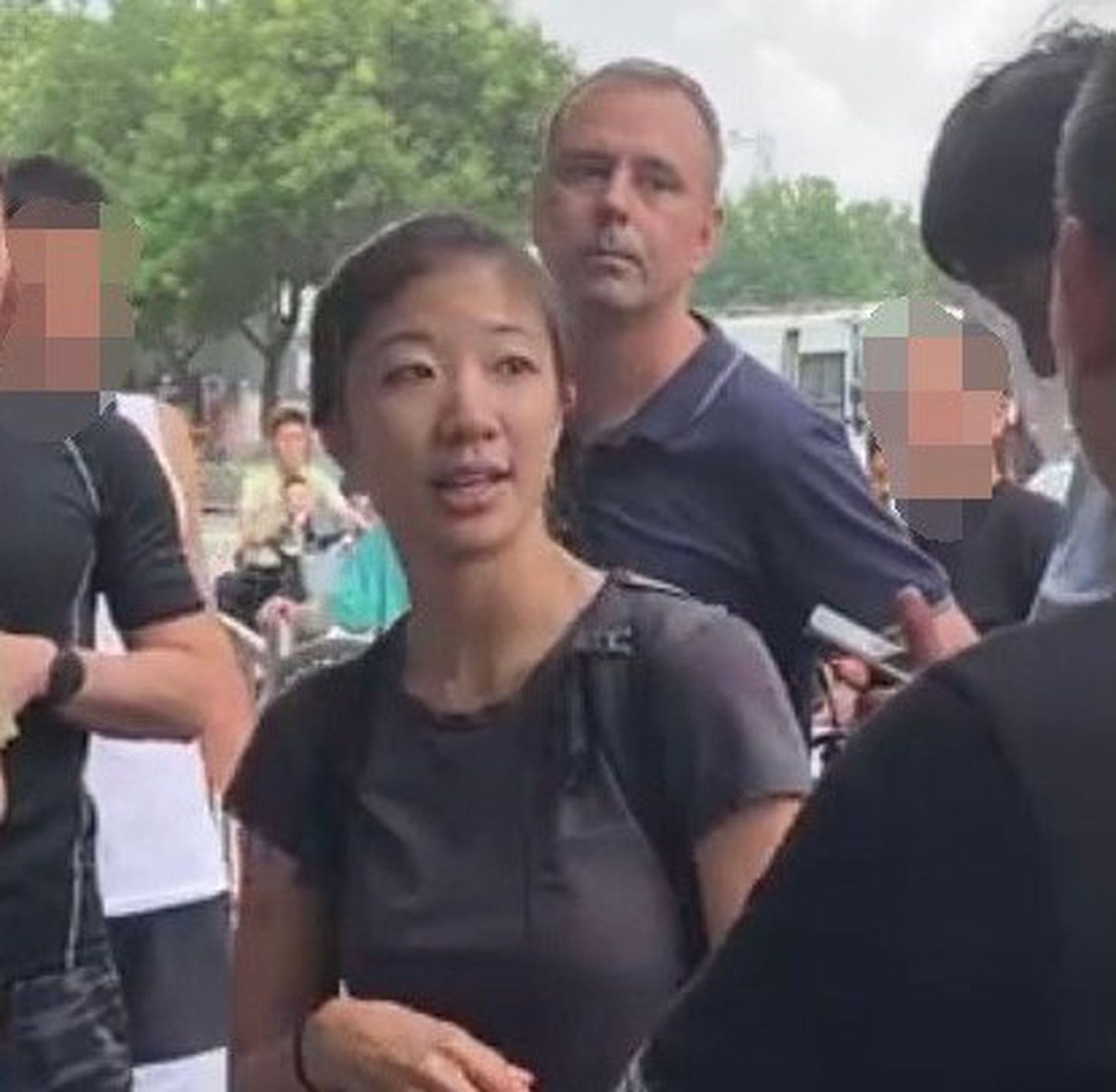 近日一名德国之声记者在郑州采访被民众围堵抗议不实报道，当时一名自称翻译的女子上前解围。（微博@冲锋号角）