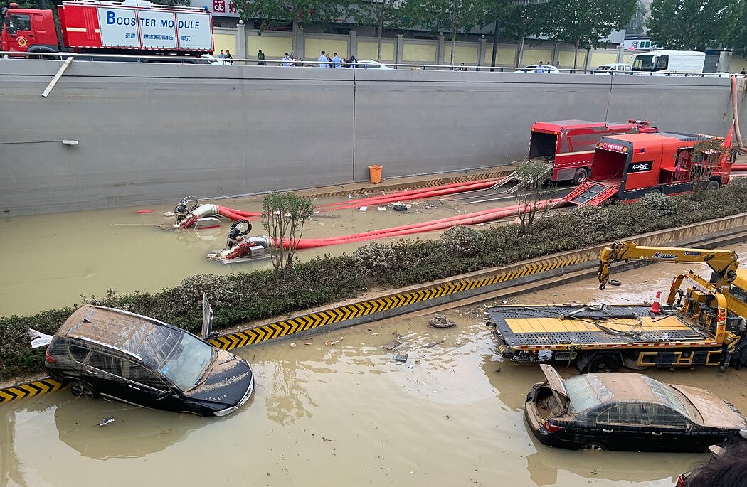 上周五下午，大功率水泵在中国郑州被水淹没的京广路隧道外进行排水作业，同时，一辆拖车正在将损坏的车辆拖走。