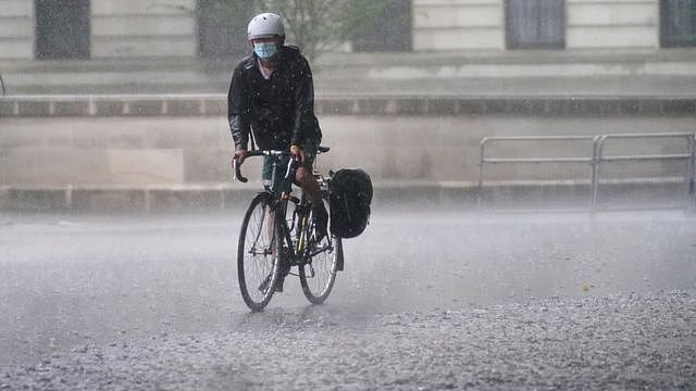伦敦市中心Horse Guards Road一位骑车者涉水而行（25/7/2021）