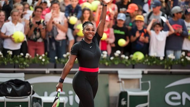Serena Williams in a black catsuit with a red band at the waits at the 2018 French Open.