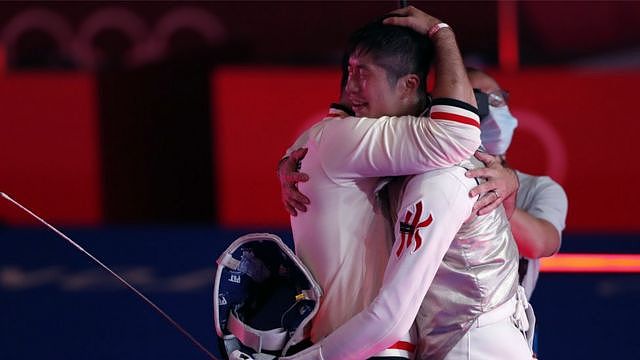 张家朗（右）在日本千叶市东京奥运男子花剑金牌赛结束后与队友拥抱庆祝（26/7/2021）