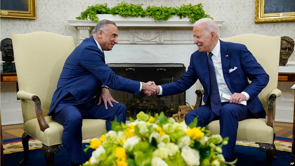 美国总统拜登（右）在白宫椭圆形办公室与伊拉克总理卡迪米（左）会晤时握手。（2021年7月26日）