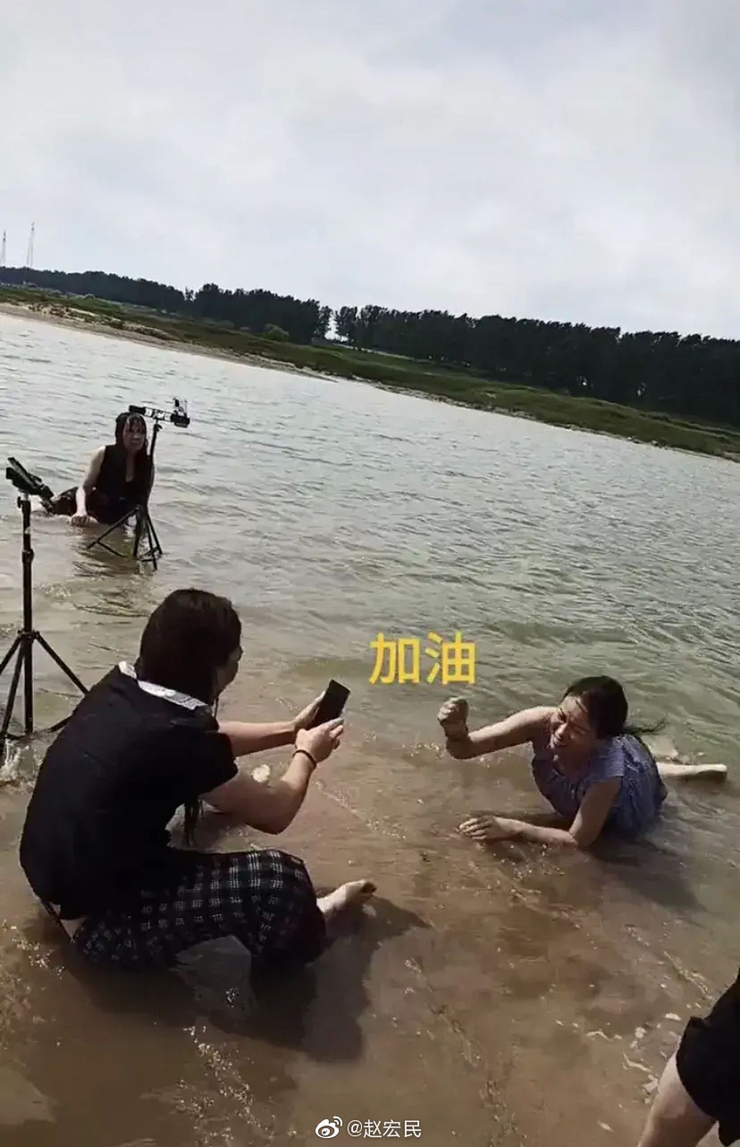 河南暴雨丑态百出，一位女子趴在水里录直播。（微博@赵宏民）