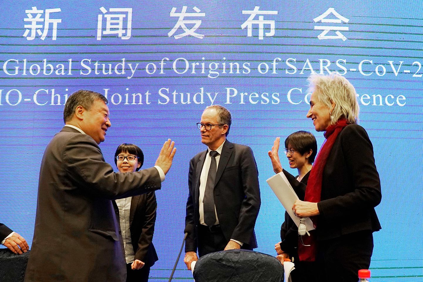 新闻发布会开始前，荷兰病毒学家库普曼斯（Marion Koopmans，右）和中国清华大学公共卫生学教授梁万年（左）互动交流。（AP）