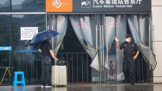 7月27日，南京汽车客运站暂停运营，在售票大厅门口，工作人员与前来乘车的乘客交谈。