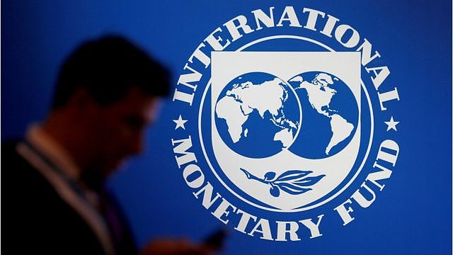 FILE PHOTO: FILE PHOTO: A participant stands near a logo of IMF at the International Monetary Fund - World Bank Annual Meeting 2018 in Nusa Dua, Bali, Indonesia, October 12, 2018. REUTERS/Johannes P. Christo/File Photo/File Photo