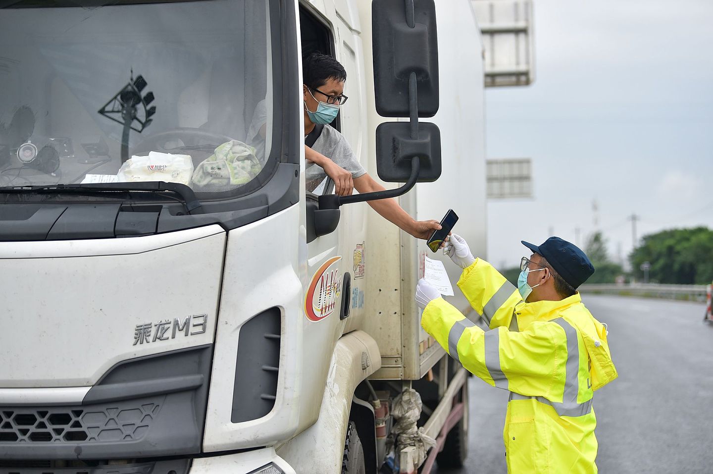 2021年7月28日，南京工作人员在西善桥收费站对经公路驾乘车辆离宁人员进行核酸阴性证明及健康码查验。（人民视觉）