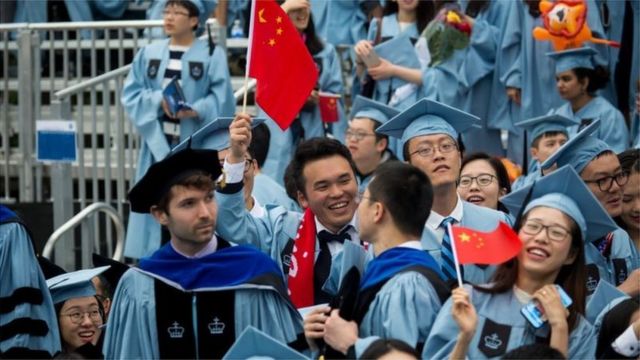 来自中国的留学生占美国留学生总数近三分之一。图为毕业生在美国哥伦比亚大学毕业典礼上手持中国国旗。