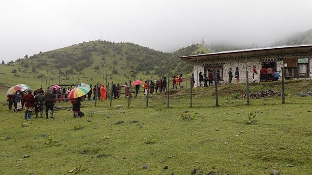 不丹东部塔希冈宗亘古村村民冒雨在村公所外排队等候接种疫苗（20/7/2021）