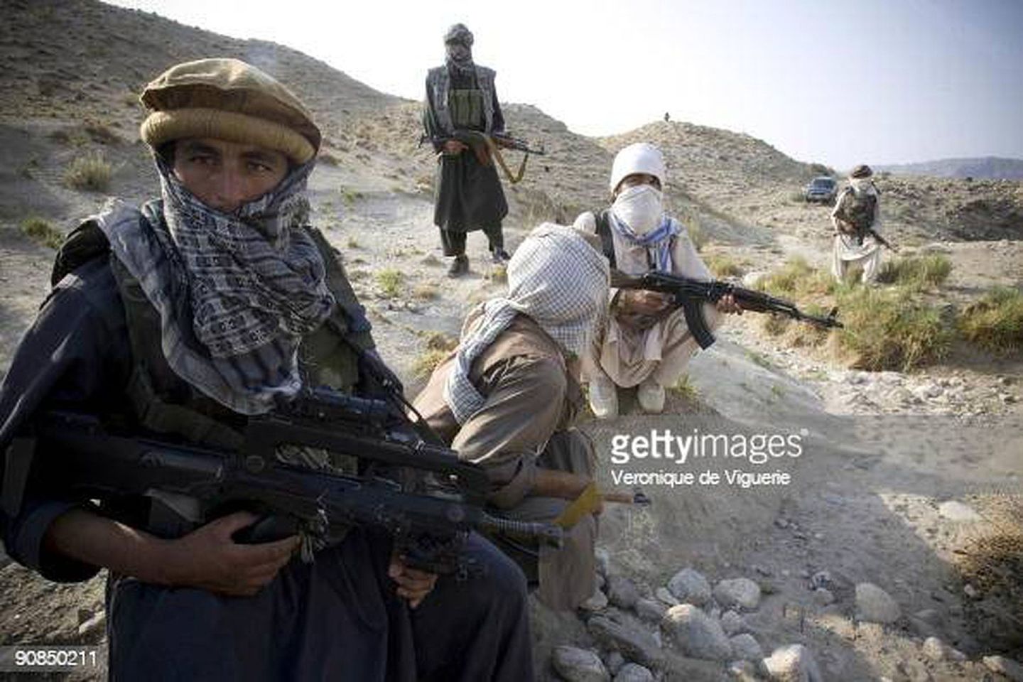 2008年8月18日，阿富汗拉各曼省，一群塔利班与基地组织成员在合作袭击一处法军边检站后休息调整。（Getty Images）