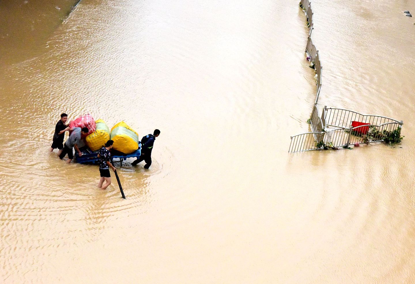 持续的强降雨，造成市区严重内涝。图为7月21日，郑州市民在转移物资。（新华社）