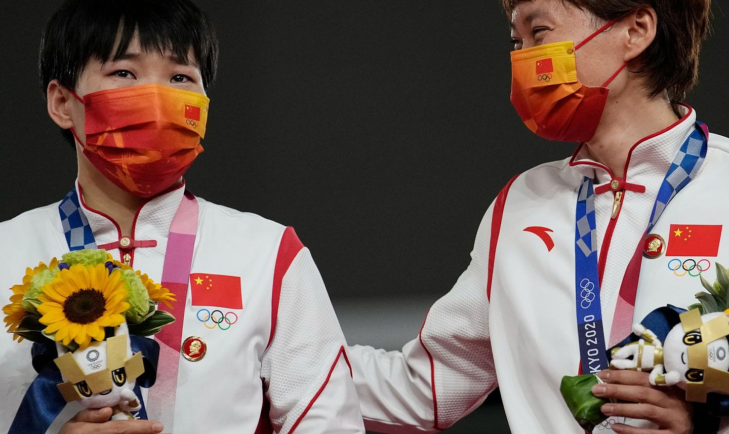2021 年 8 月 2 日，在日本伊豆举行的 2020 年夏季奥运会田径自行车女子团体冲刺决赛的颁奖仪式上，鲍珊菊（左）和中国选手钟天使因佩戴毛泽东像章引发争议。（AP）