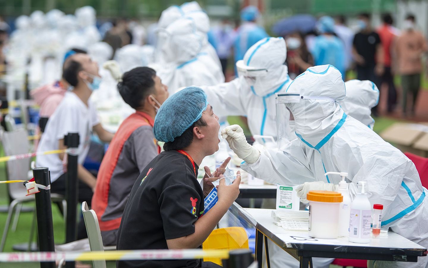 2021年8月5日，在中国海口美兰机场足球场，中国医务人员进行新冠病毒核酸检测采样。（人民视觉）