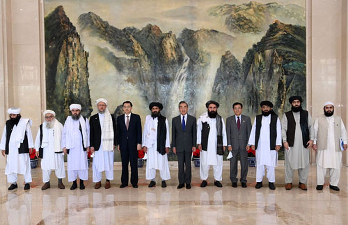 阿富汗塔利班代表团由阿塔创始人之一、政治委员会负责人巴拉达尔等9人组成。这是王毅与阿富汗塔利班代表团合影。（中国外交部官网）