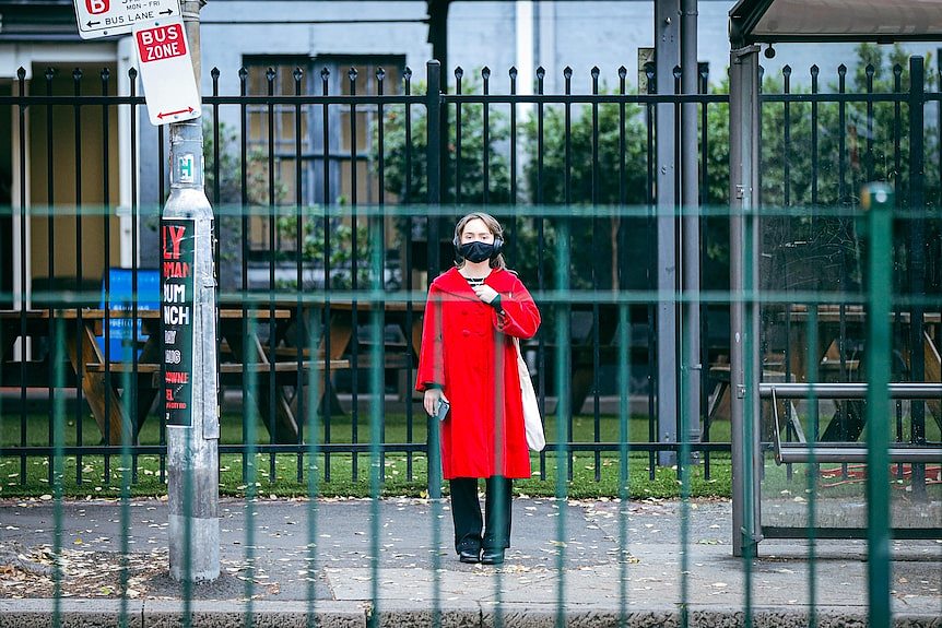 a woman standing by herself in a mask