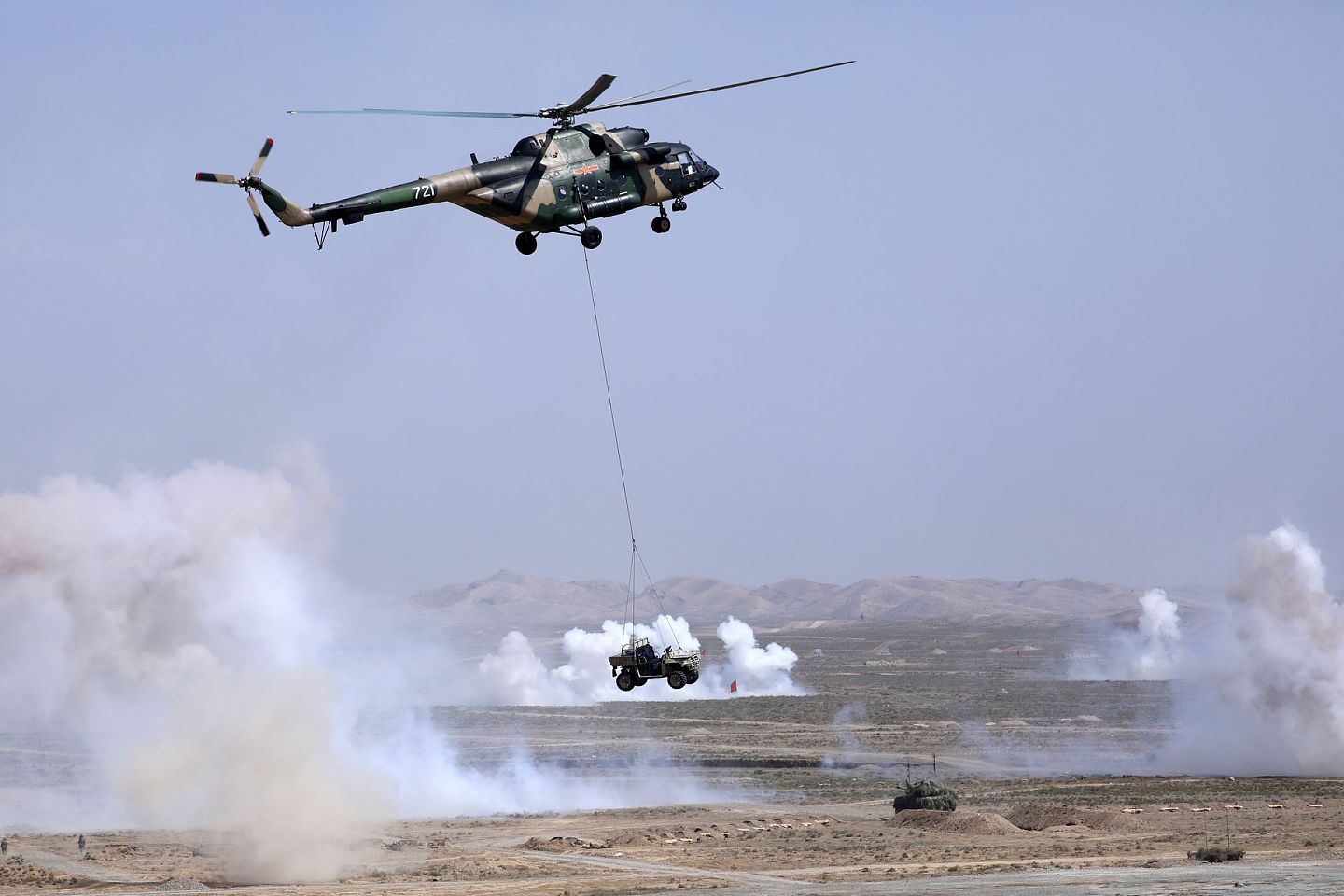 运输直升机采取外吊挂方式向“敌”前沿投送“山猫”全地形突击车。（新华社）