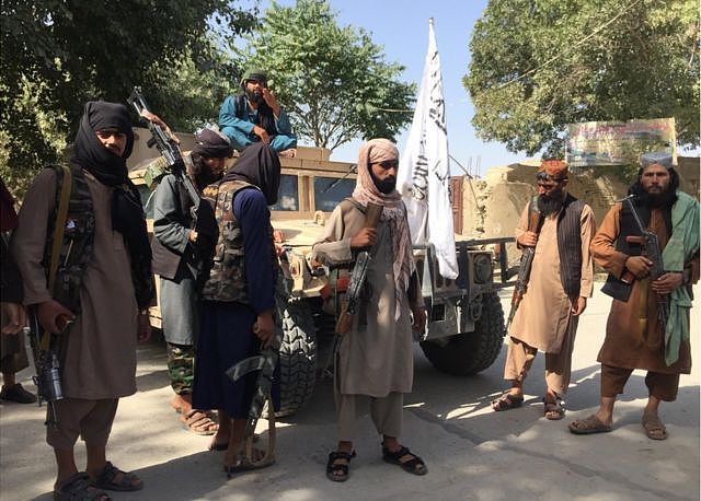 塔利班士兵炫耀他们的战利品
