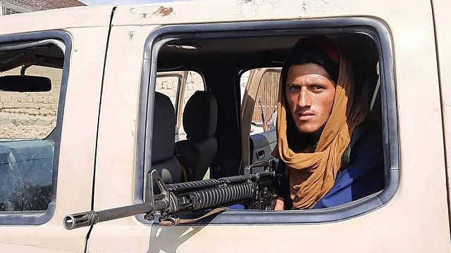 一名塔利班战士坐在拉格曼省路边的阿富汗国民军（ANA）车辆内。