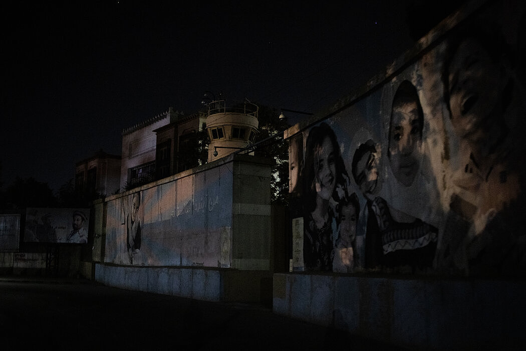 周日晚间，美国驻喀布尔大使馆的围墙。电视上直播了紧急撤离美国平民和使馆员工的画面。