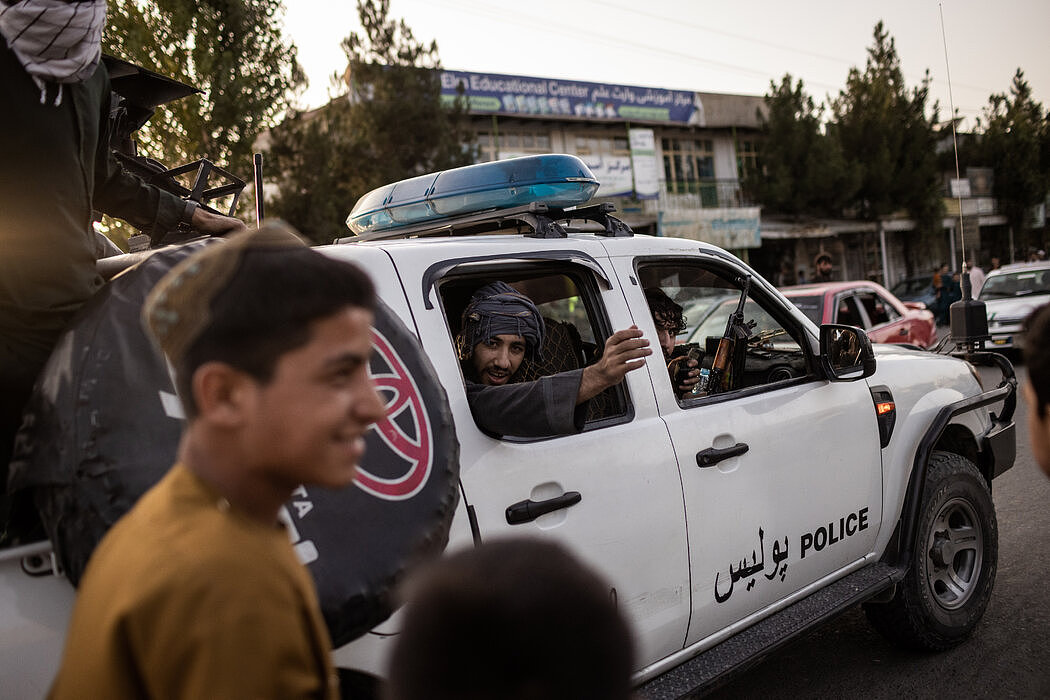 周日，塔利班成员在喀布尔一辆缴获的警车上。阿富汗政府以惊人的速度垮台。