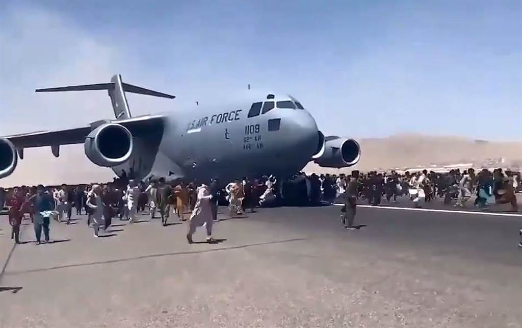 群众试图爬上起飞中的C-17。 (图/TWITTER)