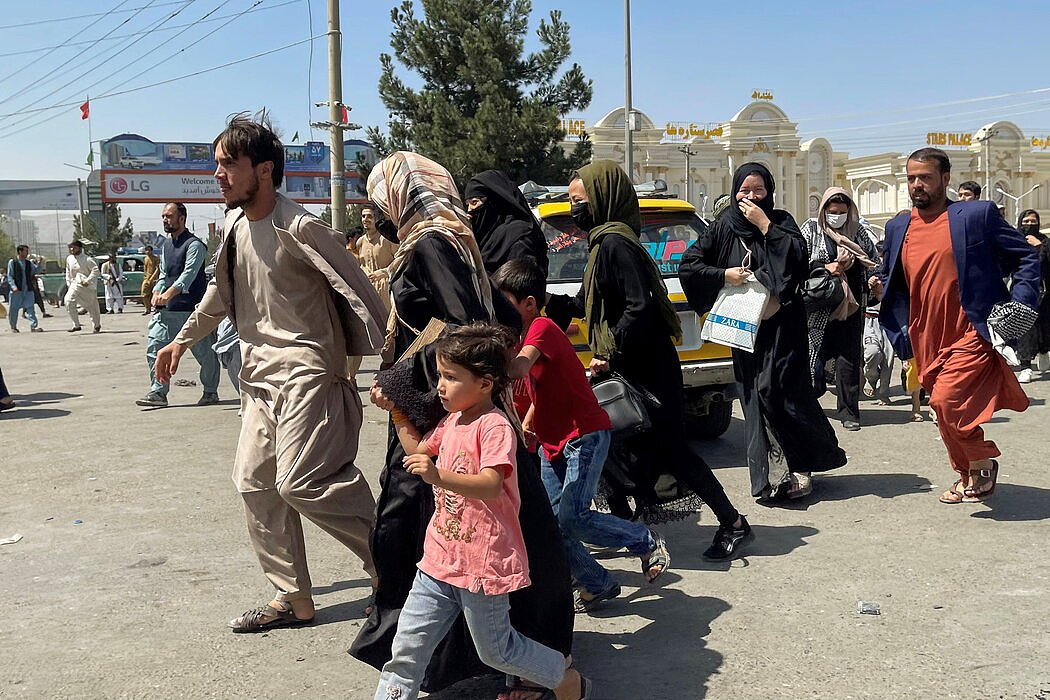 周一，在民航航班暂停的情况下，人们赶往喀布尔国际机场，希望逃离阿富汗。
