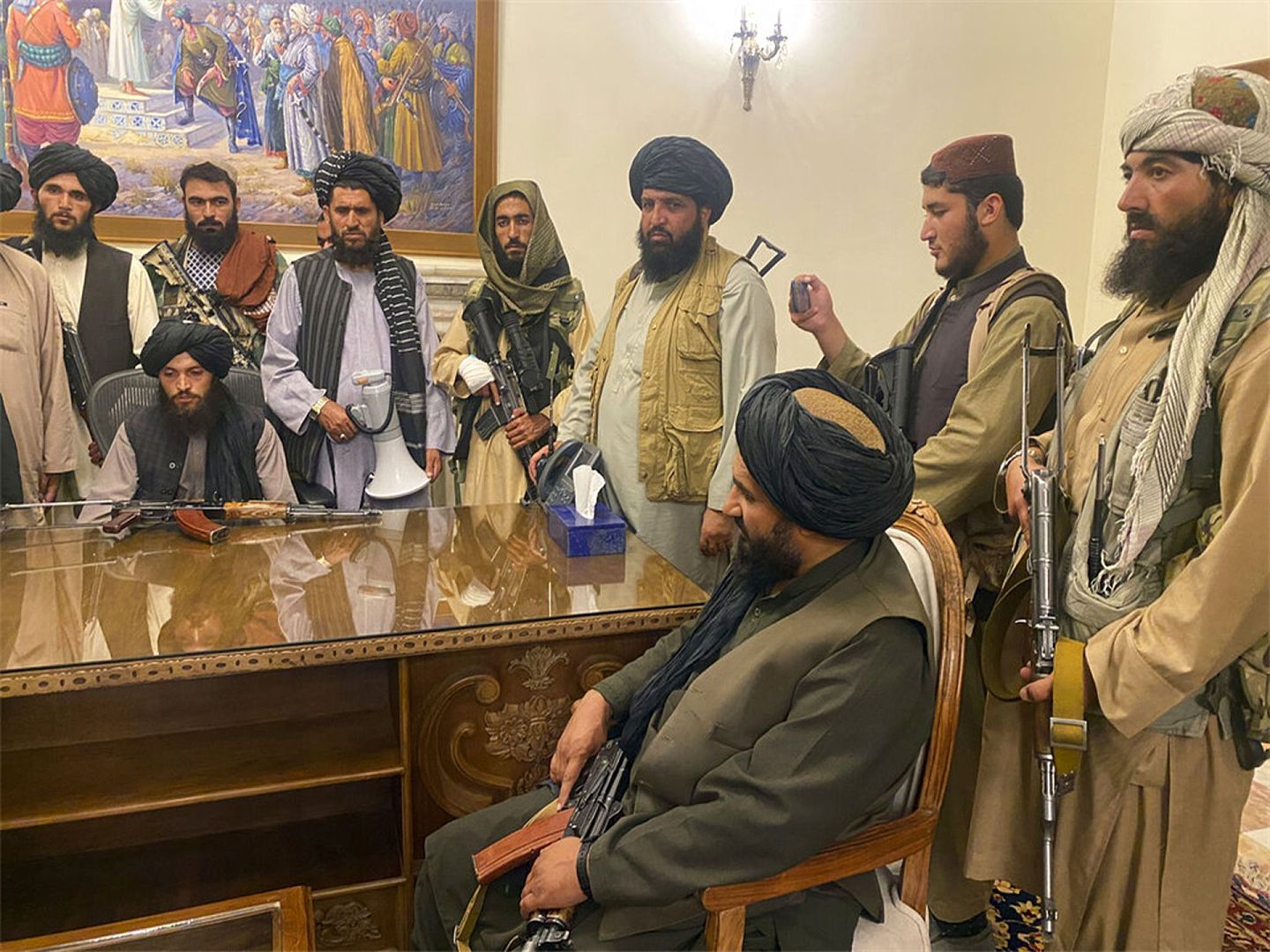 8月15日，阿富汗塔利班武装分子在总统府内交谈。（AP）