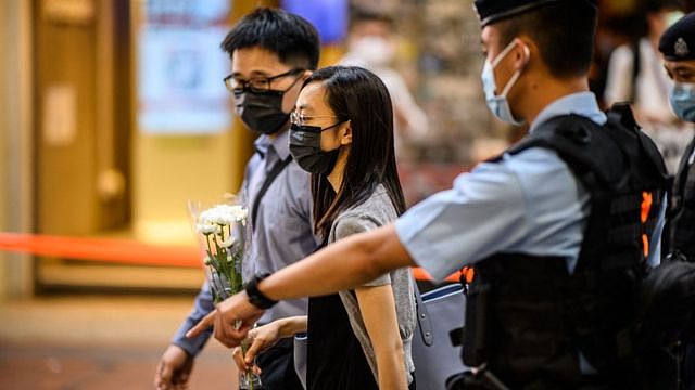 香港铜锣湾崇光百货公司外警员驱离一对手持白菊花的男女（2/7/2021）