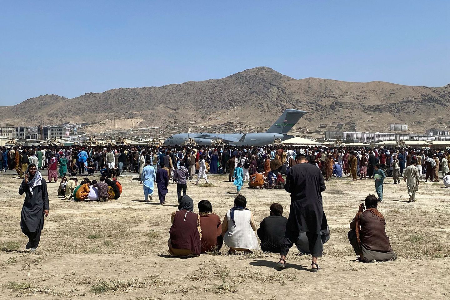 2021年8月16日，在阿富汗喀布尔国际机场，数百人在一架美国空军C-17运输机的跑道上奔跑。（AP）