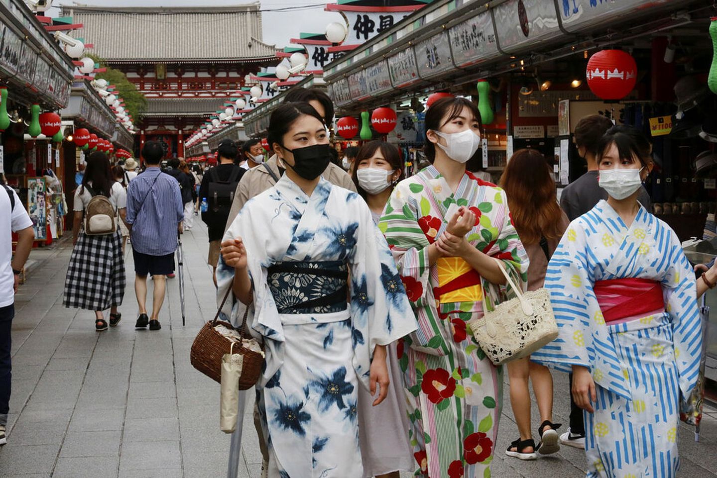 图为2021年8月13日，日本东京都浅草仲见世商店街有身穿浴衣和戴口罩的人经过。（AP）