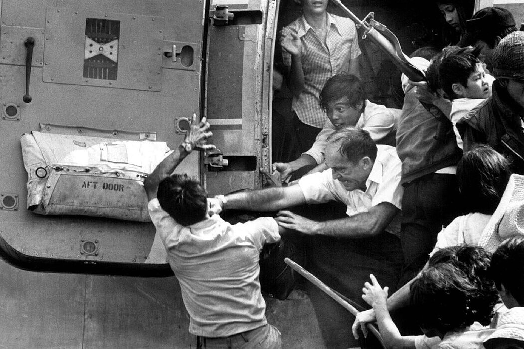 1975年4月1日，越南芽庄，一名美国官员在一架满载难民的飞机的门口用力殴打一名男子，试图将他推下飞机。