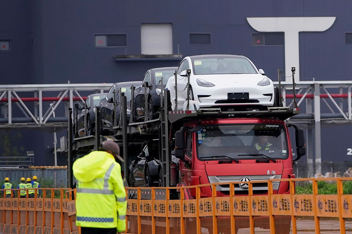 图为中国上海一架货车在Tesla工厂运送新车。（Reuters）