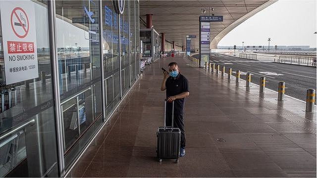 A passenger wearing a protective face mask stands at the entrance to the terminal 3 departure hall of Beijing Capital International Airport, amid the coronavirus pandemic in Beijing, China, 05 August 2021.