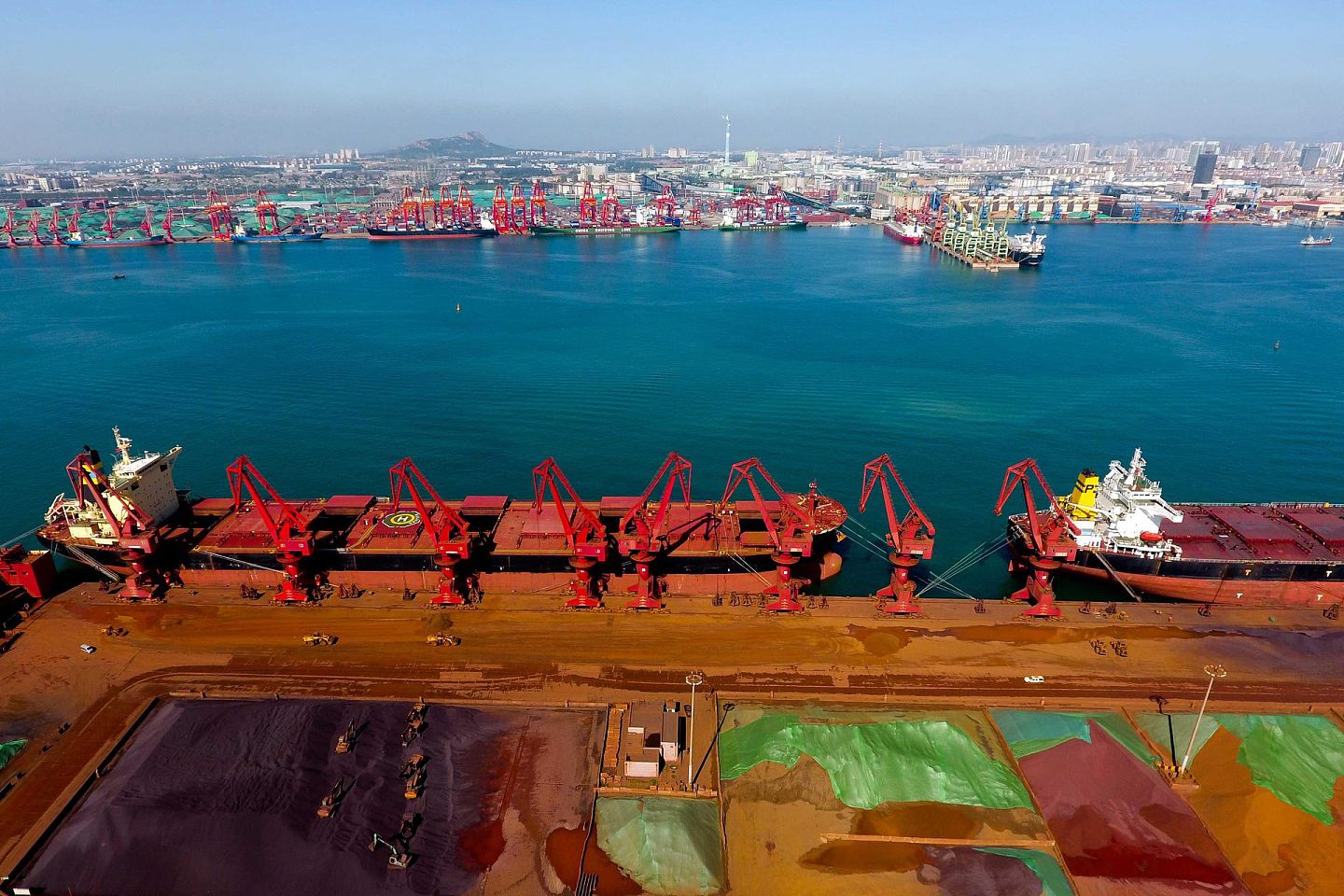日照港三十万吨铁矿石码头，起重机在装载货物。（新华社）