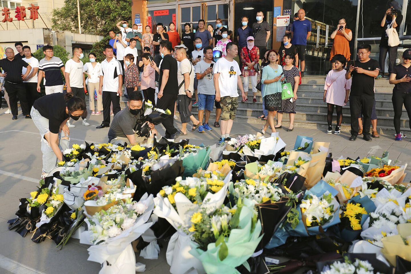 2021年7月27日，中国民众在河南暴雨灾害出事地铁站口吊唁遇难者。（AP）