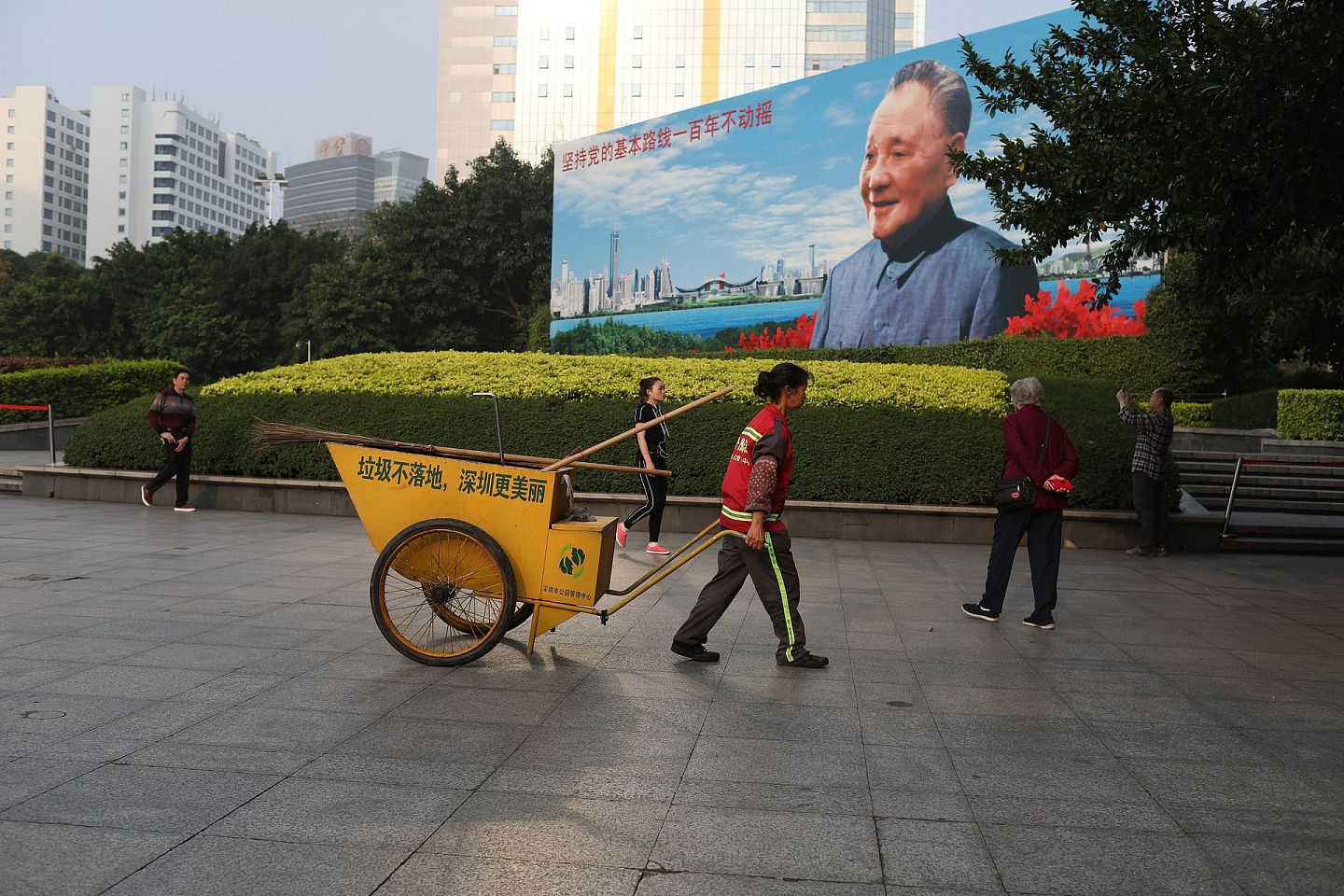 深圳环卫工人从邓小平画像广场经过。（视觉中国）