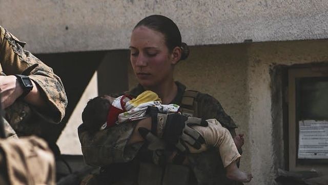 美国海军陆战队中士妮可·吉（Nicole Gee）抱着一个阿富汗婴儿