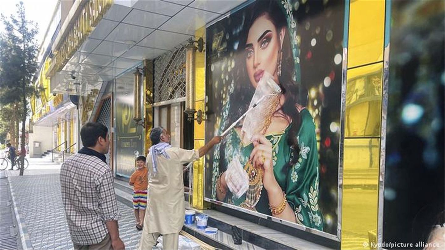 在听说塔利班已攻入喀布尔后，喀布尔一家美容院急忙遮盖橱窗上有性感画面的广告。（Getty）
