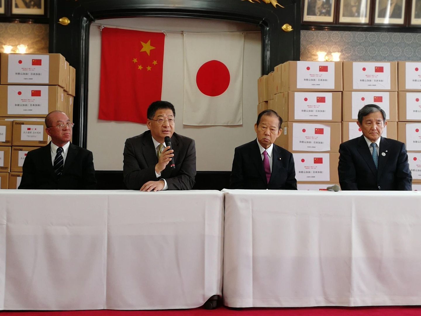 2020年3月21日，中国驻大阪总领事何振良（左二）出席防疫物资捐赠仪式并发表讲话，日本自民党干事长二阶俊博（左三）对中方捐赠表示感谢。（新华社）