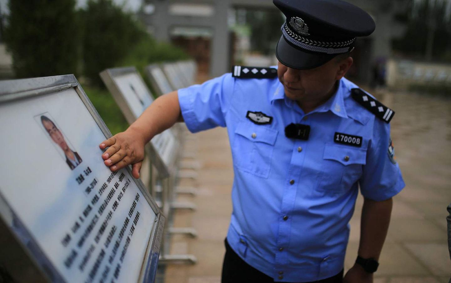 当地民警为牺牲的战友擦拭纪念牌。（微博@范凌志）
