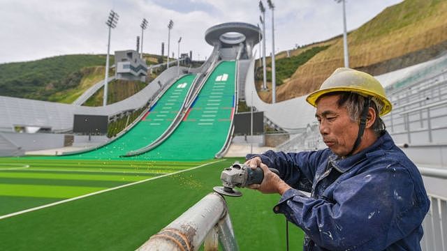 张家口崇礼的一名工作人员正在对跳台滑雪场地进行最后的收尾工作。