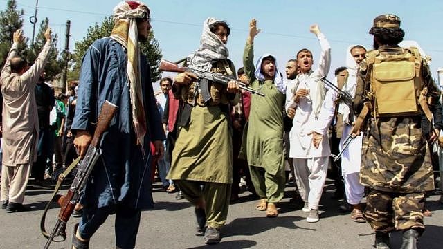 Armed Taliban fighters stand guard as protesters march in Kabul, Afghanistan. Photo: 7 September 2021