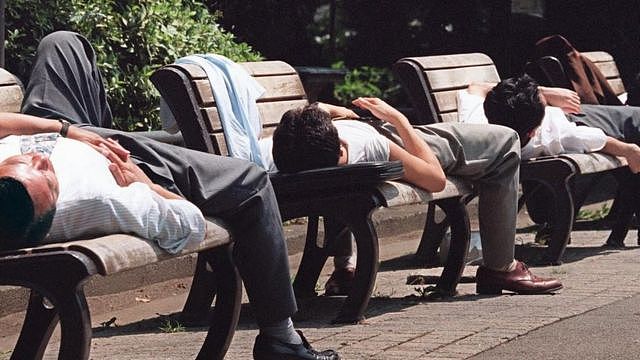 Men sleeping in benches